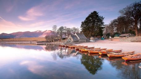 Tranquil Lakeside with Wooden Boats and Mountain Backdrop wallpaper