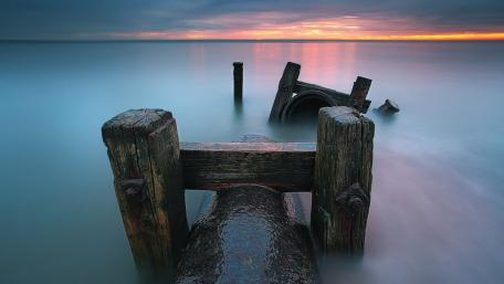 Serene Sunset Over Abandoned Dock Ruins wallpaper