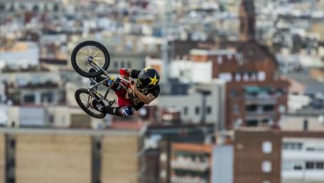Freestyle BMX Stunt Above the Cityscape wallpaper