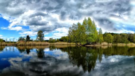 Tranquil Lake Reflections Under Clouded Skies wallpaper
