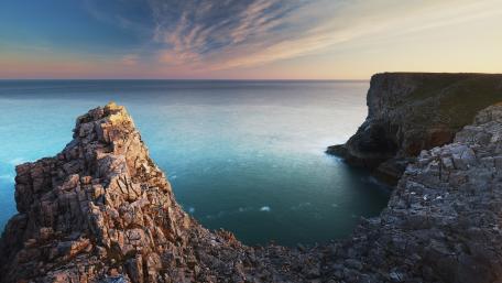 Majestic Cliffs Overlooking Tranquil Sea at Dusk wallpaper