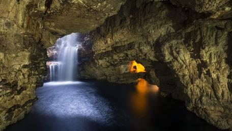Majestic Cave with Hidden Waterfall and Tranquil Lake wallpaper