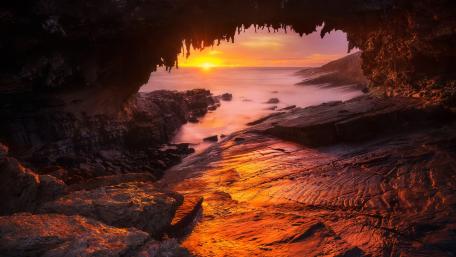 Serene Sunset Through a Sea Cave Opening wallpaper