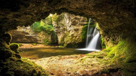 Serene Grotto with Cascading Waterfall in Nature wallpaper