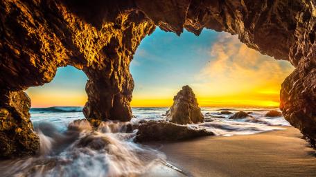 Ocean Sunset Through a Majestic Sea Cave wallpaper