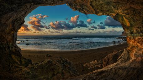 A Breathtaking View Through a Coastal Cave Window wallpaper