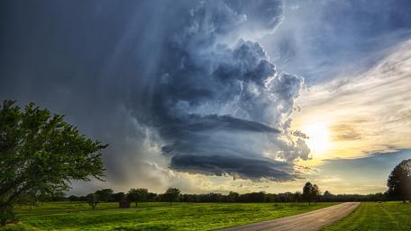 Majestic Storm Clouds Over a Tranquil Landscape wallpaper