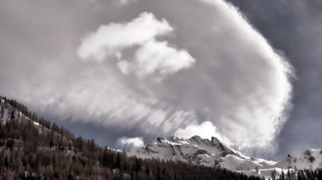 Majestic Snow-Capped Peaks Under Dramatic Clouds wallpaper