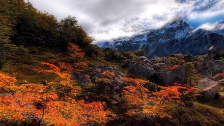 Autumn Mountainscape with Vibrant Foliage and Clouds wallpaper