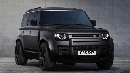 Sleek Black Land Rover Defender Against Concrete Wall wallpaper