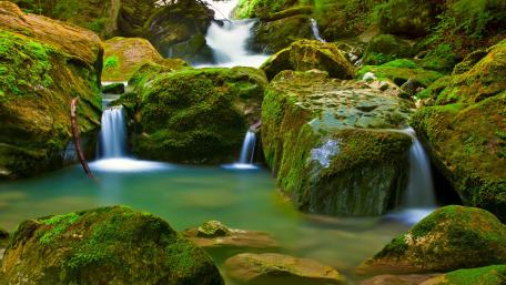Waterfall Oasis Amidst Mossy Stones wallpaper