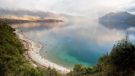 Serene Rainbow Reflection Over a Tranquil Lake wallpaper