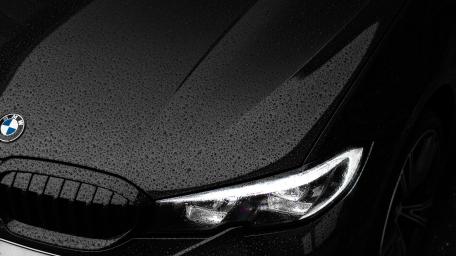 Sleek Black BMW in Rainy Elegance wallpaper