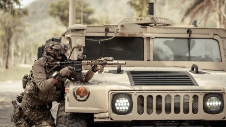 Soldier in Action by Armored Vehicle in 4K wallpaper