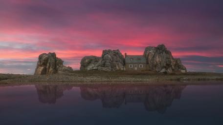 Charming Cottage Nestled Between Rocks at Sunset wallpaper
