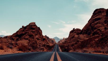 Road Through Majestic Red Rock Formations in Nevada's Wilderness wallpaper
