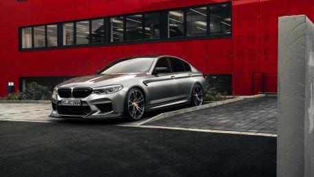 BMW M5 Stands Out Against Vibrant Red Backdrop wallpaper