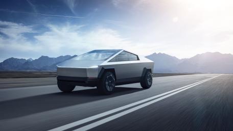 Tesla Cybertruck and remote desert highway with mountain ranges in the distance under a bright sky. wallpaper