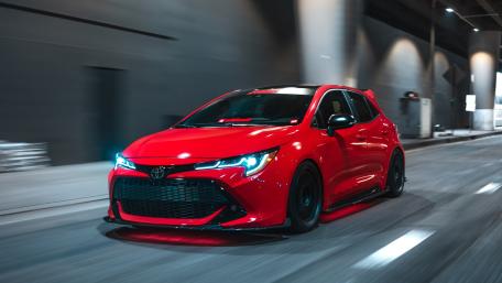 Red Hot Hatchback Racing Through Midnight City Streets wallpaper