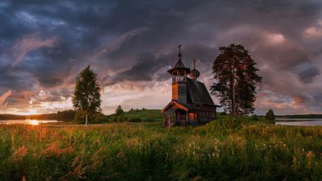 Stormlit Sunset Over a Wooden Chapel in Rural Arkhangelsk wallpaper