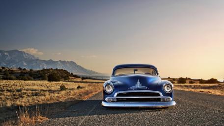 Blue Chevrolet Hot Rod Cruising a Desert Highway at Golden Hour wallpaper