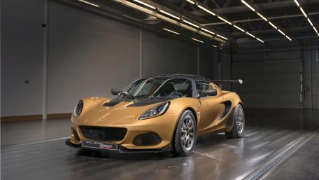 Golden Lotus Elise in Modern Studio 4K Wallpaper wallpaper