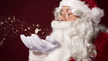 Santa Blowing Snowy Magic on Deep Red Christmas Night wallpaper