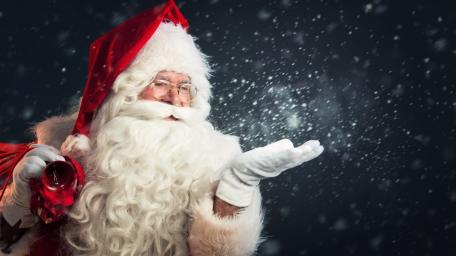Santa Claus Blowing Snowy Christmas Magic in a Winter Night wallpaper