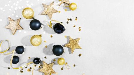 Minimalist Christmas Celebration with Gold Stars and Black Ornaments wallpaper