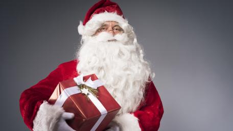 Santa Claus Holding Wrapped Gift in Festive 5K Holiday Portrait wallpaper