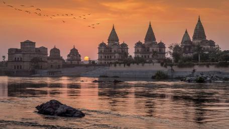 Sunset Over Orchha Temples Along the Betwa River in 4K wallpaper