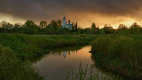 Golden Evening Over Riverside Temple and Silent Meadow Canal wallpaper