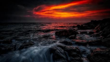 Crimson Twilight Over a Stormy Sea Horizon in Burning Sunset Glow wallpaper