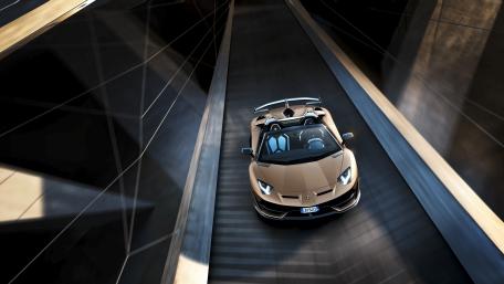 Golden Lamborghini Aventador SVJ Roadster Racing Through Urban Shadows wallpaper