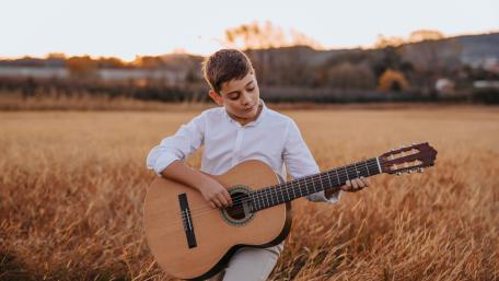 Golden Hour Acoustic Guitarist in Autumn Field Serenity wallpaper