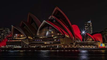 Sydney Opera House Glowing Red Over Harbour Waters at Night wallpaper