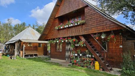 Flower Adorned Wooden Cottage Home Under Bright Blue Skies wallpaper
