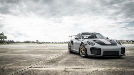 Porsche 911 GT2 Poised on Open Tarmac Under Brooding Skies wallpaper