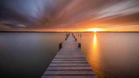 Sunset Serenity Over a Wooden Pier on a Calm Lake wallpaper