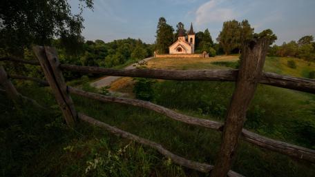 Hilltop Chapel Beyond the Rustic Fence at Golden Hour wallpaper
