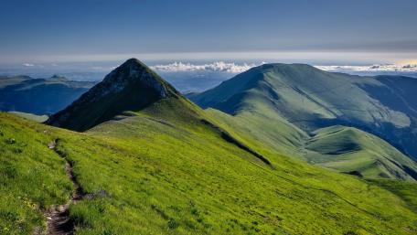 Sunlit Green Mountain Ridges Above a Sea of Clouds wallpaper