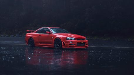 Red Nissan Skyline GT-R R34 Racing Through the Rainy Night wallpaper