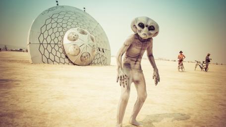 Alien Wanderer at Desert Festival Under a Futuristic Dome wallpaper