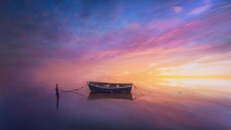 Tranquil Dinghy Drifting Toward a Luminous Dusk Horizon wallpaper