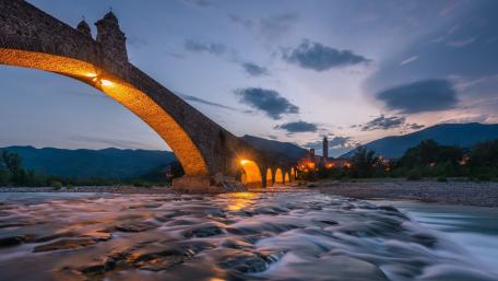 Twilight Reflections Under Ponte Gobbo in Bobbio Italy wallpaper