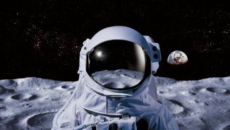 Lone Astronaut on Moon Surface with Earth Rising in Deep Space wallpaper