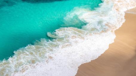 Turquoise Ocean Waves Meeting Golden Sand In Aerial Serenity wallpaper