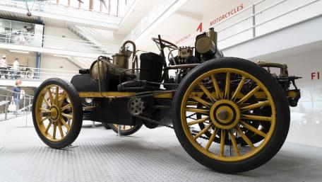 Antique Museum Classic Car with Golden Spoked Wheels on Display wallpaper