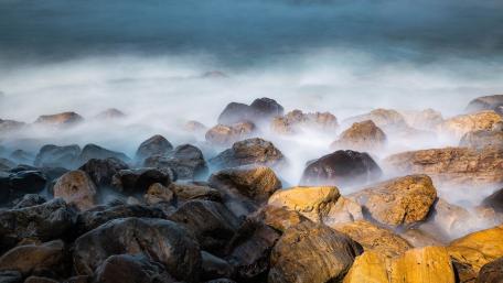 Misty Coastal Boulders in Soft Morning Surf wallpaper