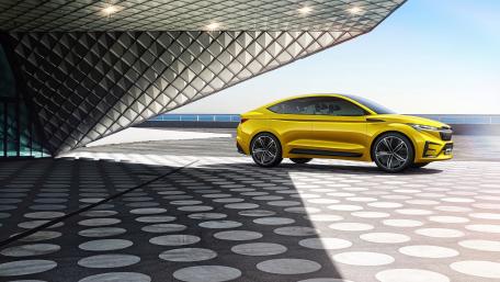 Sleek Yellow Skoda Vision iV Concept SUV Under Modern Architecture wallpaper